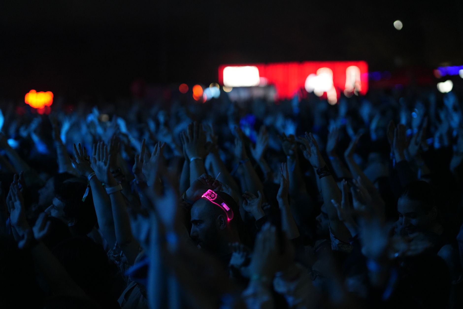 Concert crowd under neon lights evoking a 90s music festival atmosphere