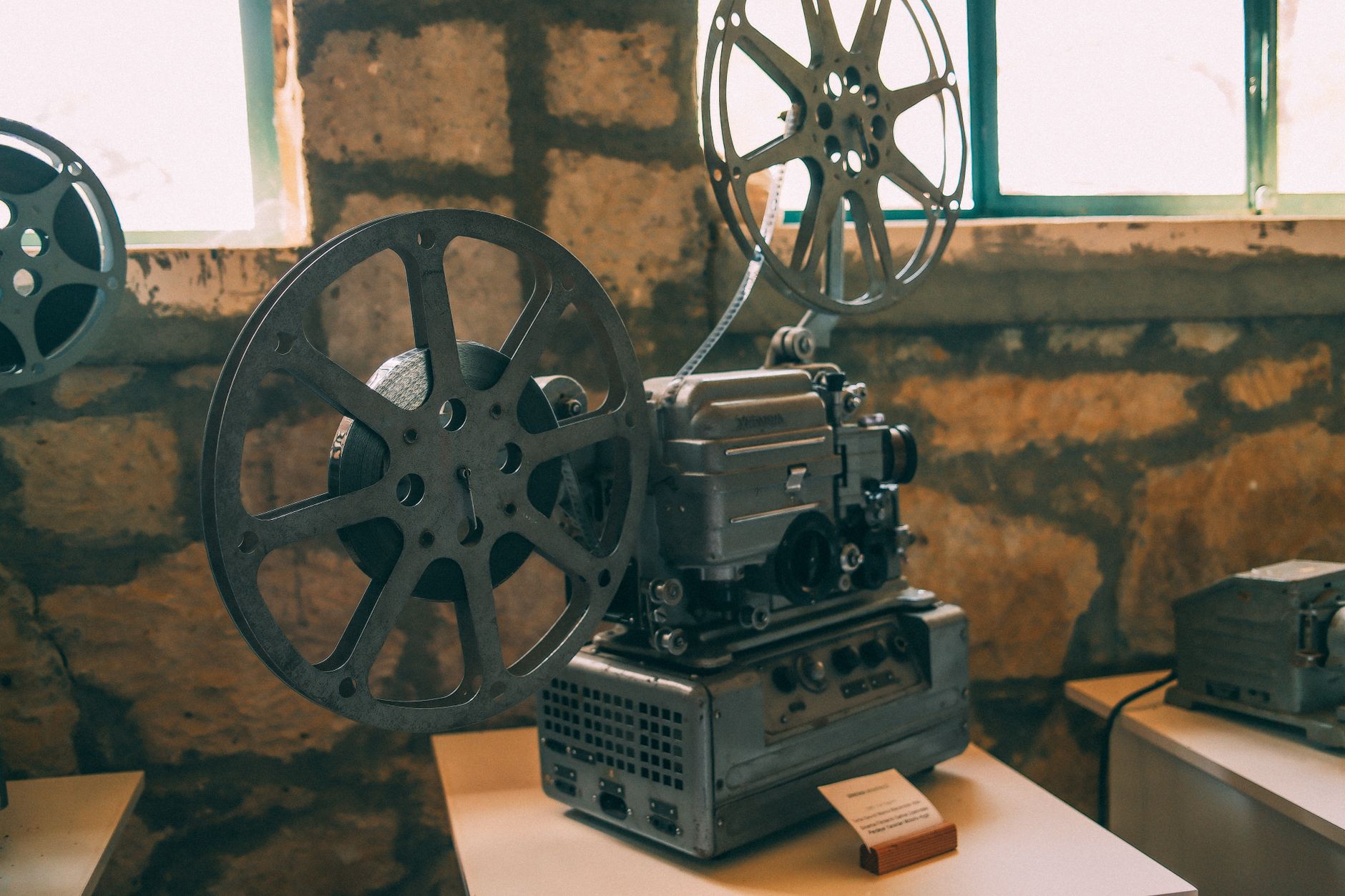 Vintage film reel and cinema projector in dim light
