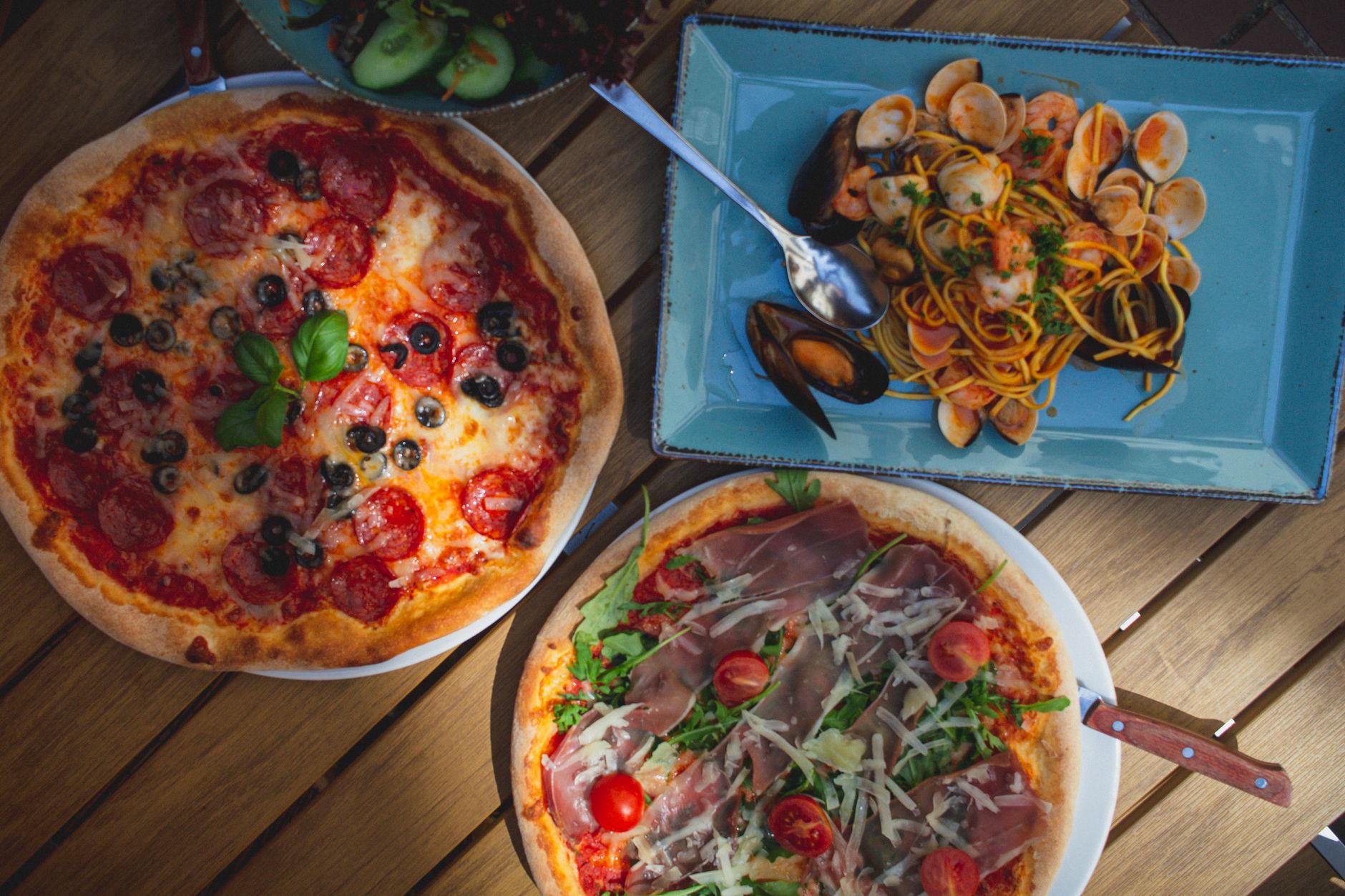Fresh pizza and pasta dishes representing Italian cuisine
