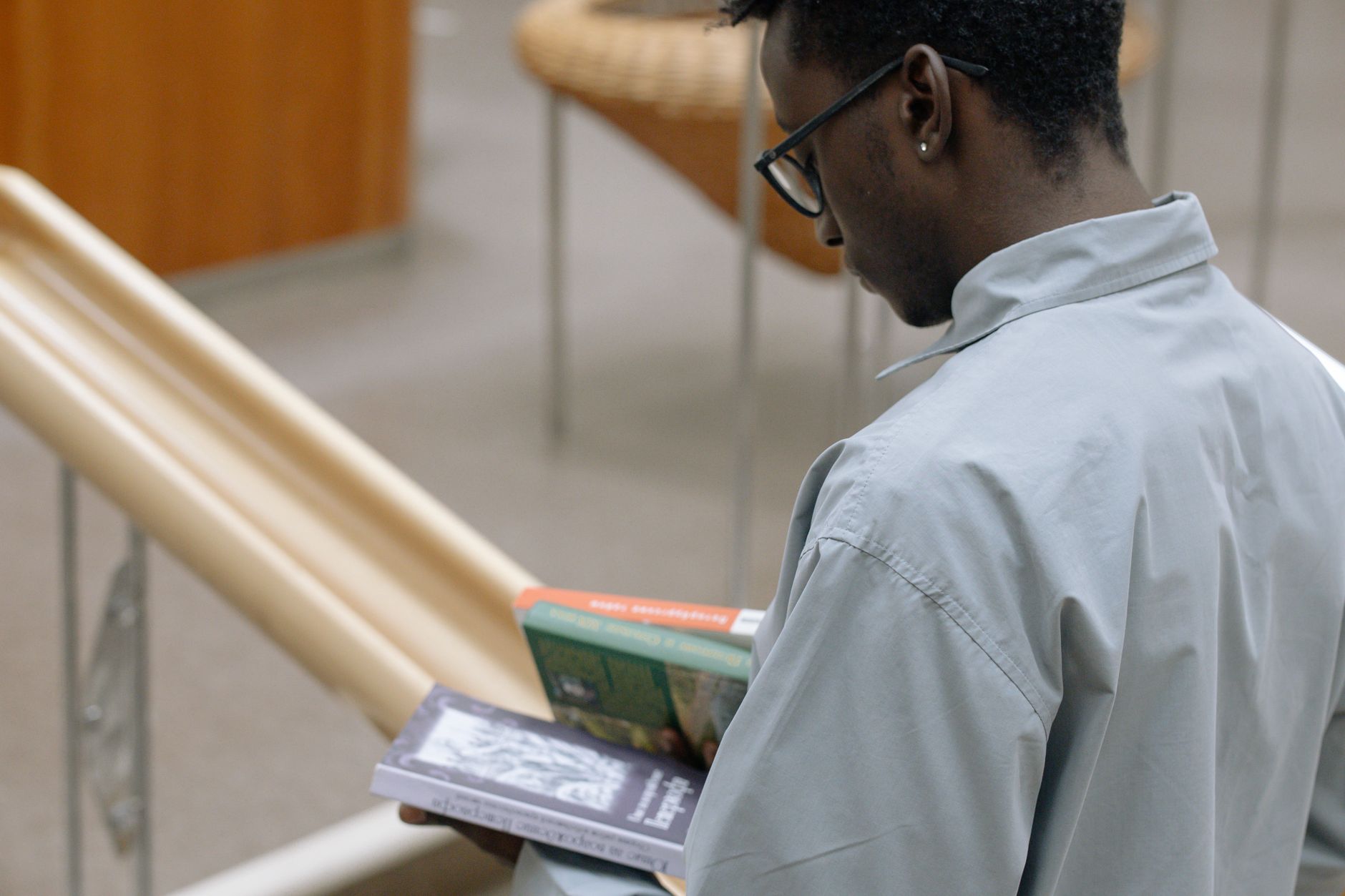 Person reading a book in a library, studying general knowledge