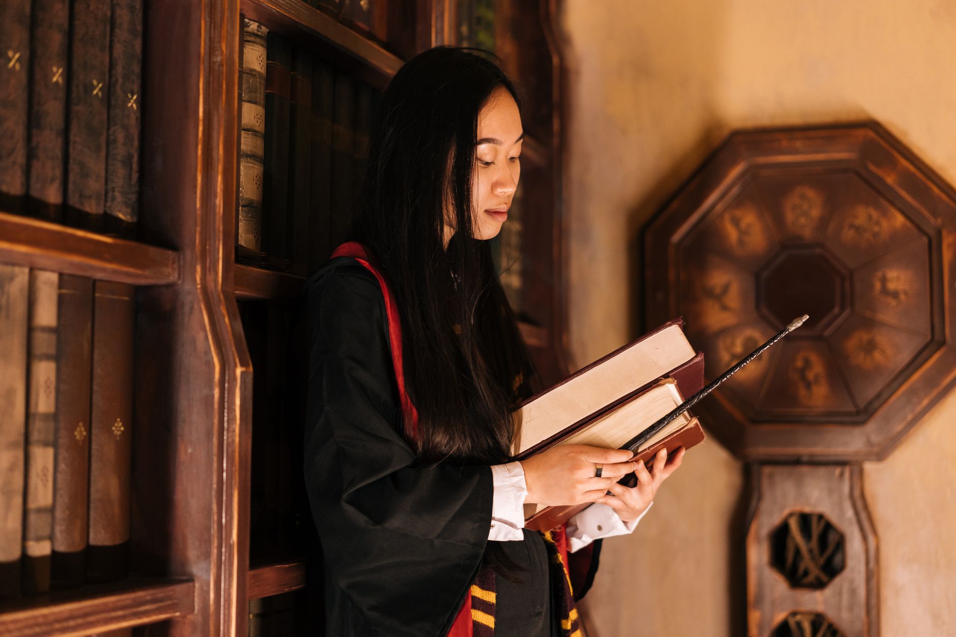 Fantasy books and reading in a grand library setting similar to Hogwarts