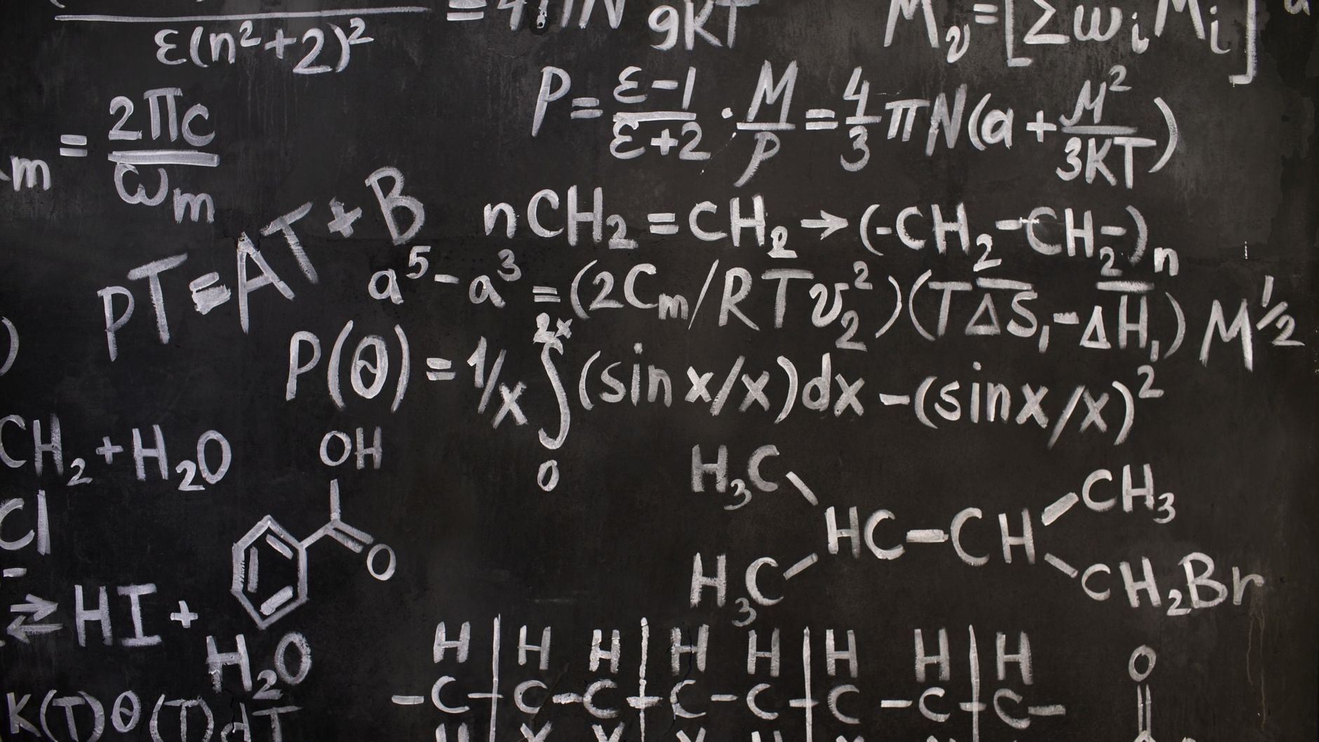 Science classroom blackboard covered in physics equations