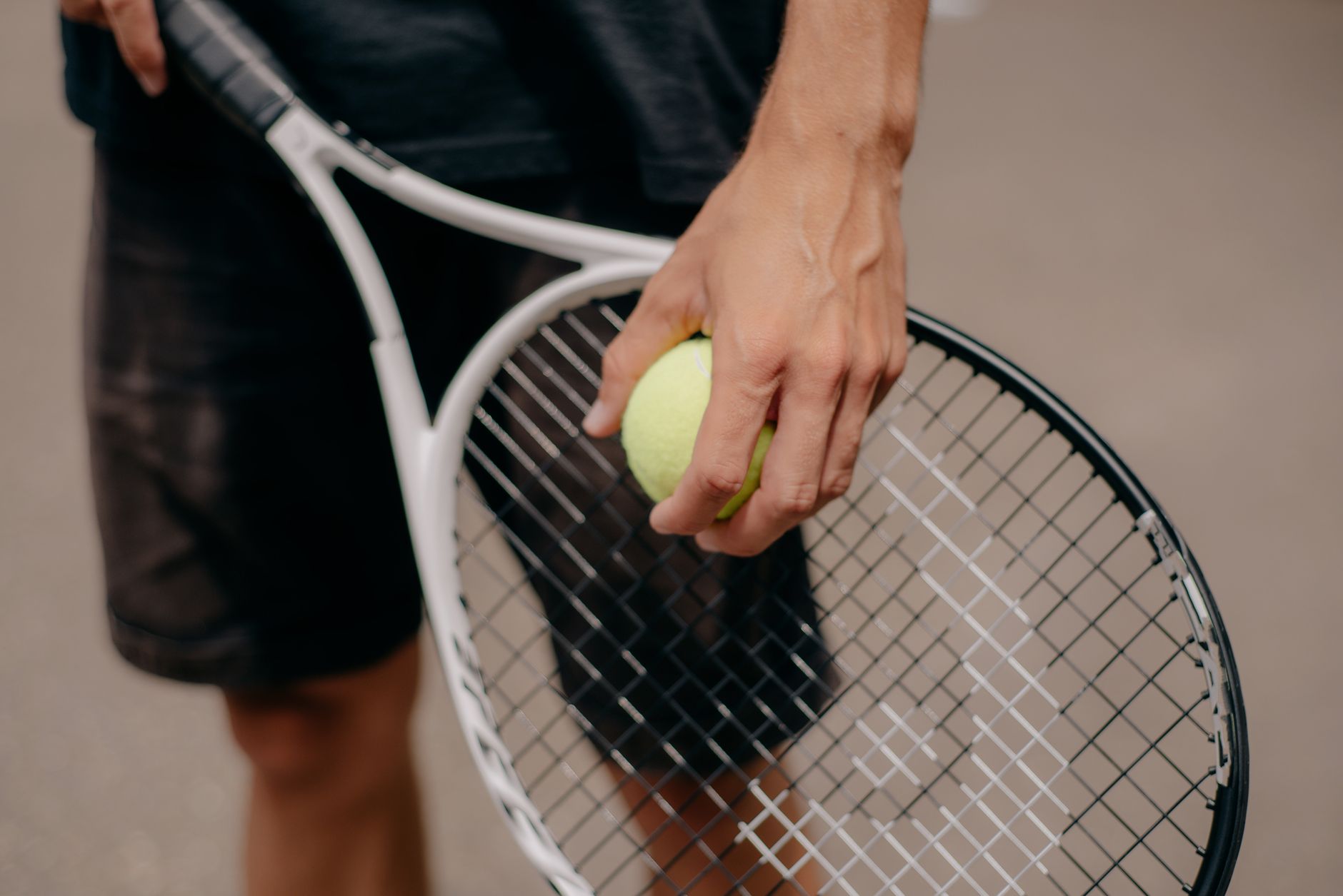 Tennis racket and ball resting on the court