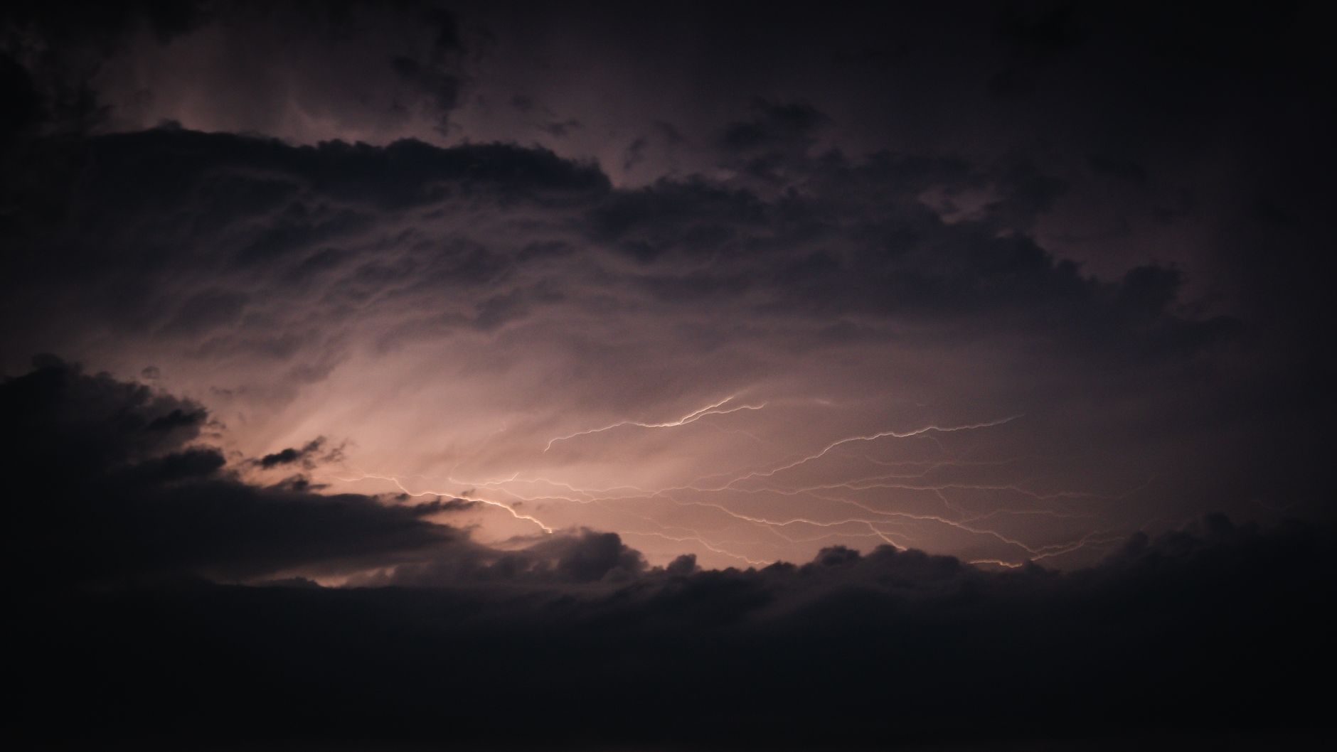 Dark storm clouds with lightning over an open landscape