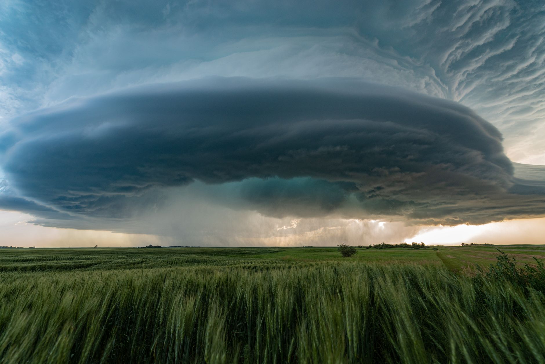 Supercell storm cloud formation over a rural landscape