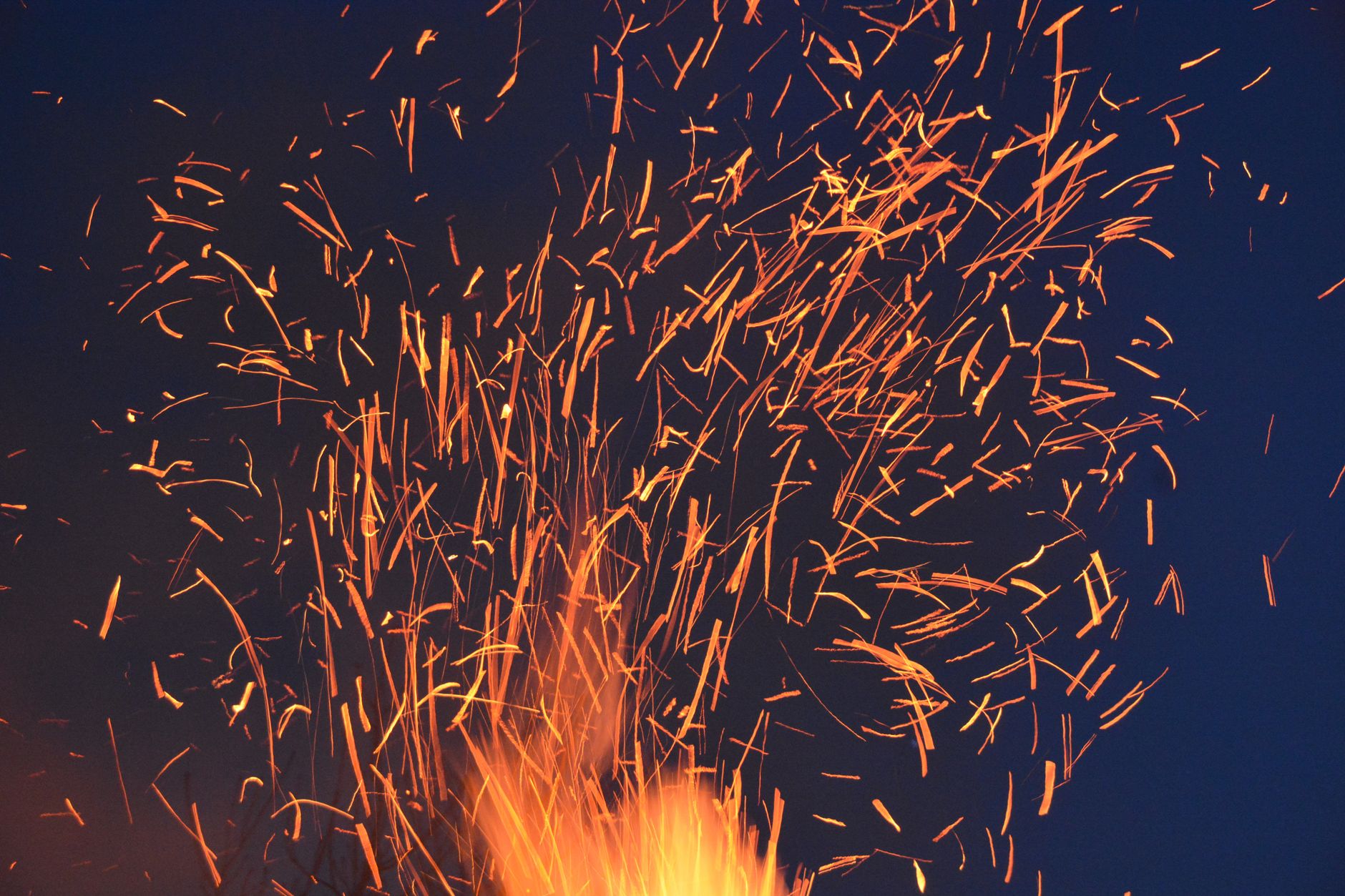 Bonfire sparks flying at night, representing the passionate energy of Fire personalities